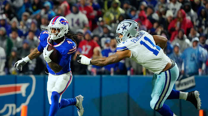 Bills running back James Cook (4) runs the ball pressured by Cowboys linebacker Micah Parsons (11) in the second half at Highmark Stadium.